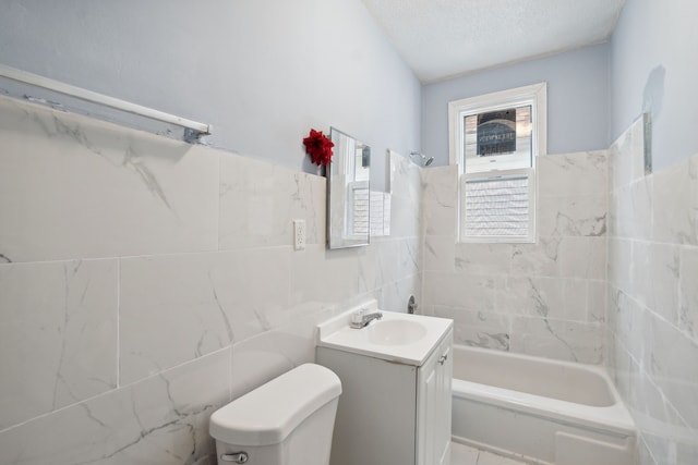 full bathroom with a textured ceiling, toilet, vanity, tile walls, and tiled shower / bath