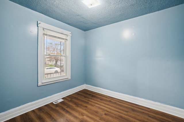 empty room featuring a textured ceiling and hardwood / wood-style flooring