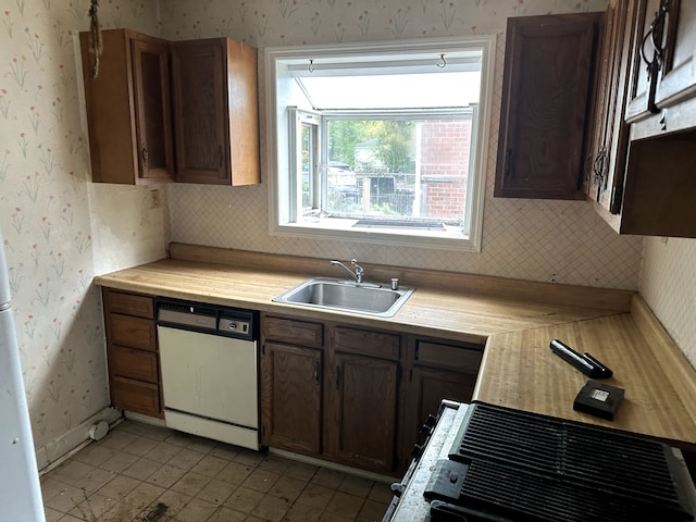 kitchen with stove, white dishwasher, and sink