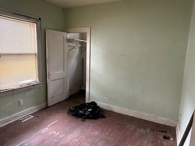 3950 Cadieux Rd, Detroit, MI 48224 - unfurnished bedroom featuring wood-type flooring, multiple windows, and baseboards