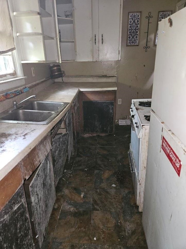 kitchen with white appliances, white cabinetry, and sink