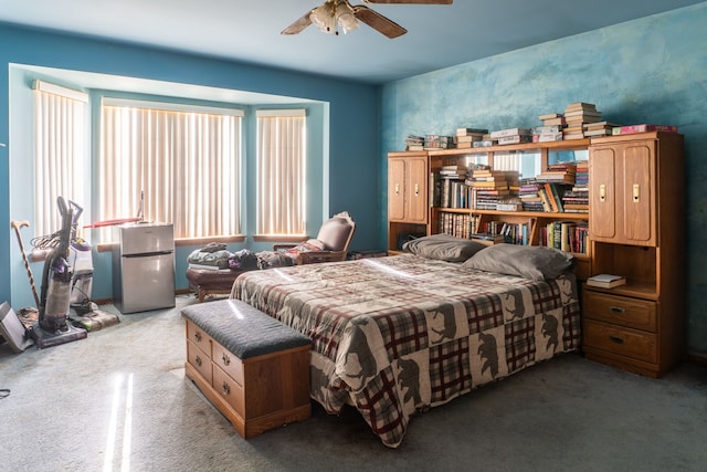 carpeted bedroom with ceiling fan and stainless steel refrigerator