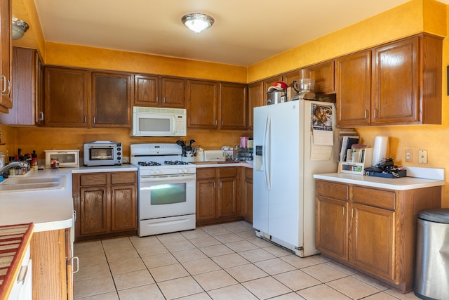 kitchen featuring sink, light tile patterned flooring, and white appliances