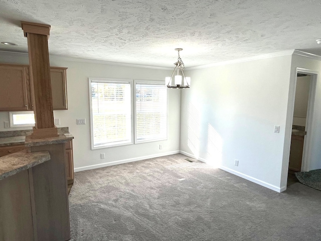 unfurnished dining area featuring dark colored carpet, a textured ceiling, an inviting chandelier, and ornamental molding