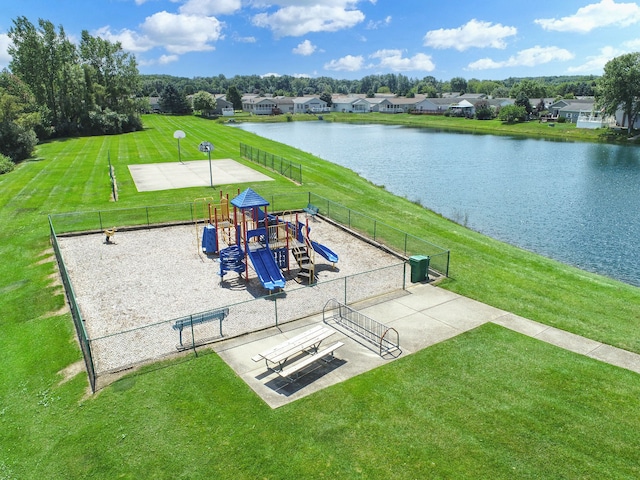 view of property's community featuring a playground, a yard, and a water view