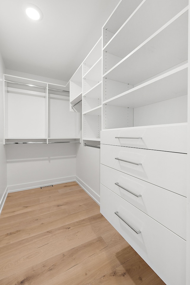 walk in closet with hardwood / wood-style flooring