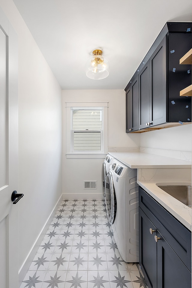 laundry room featuring washer and clothes dryer and cabinets