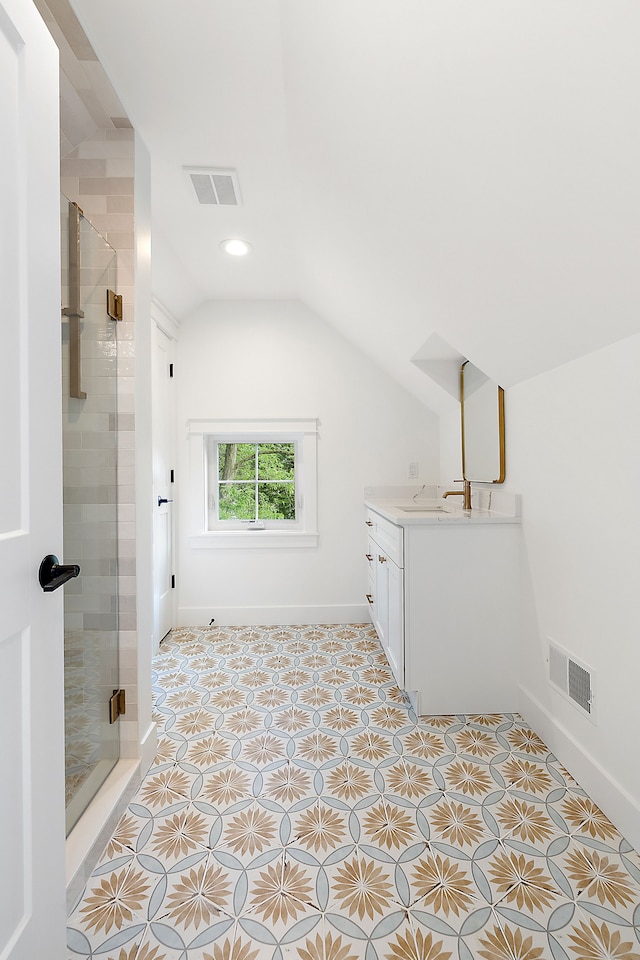 bathroom featuring a shower with door, vanity, and lofted ceiling