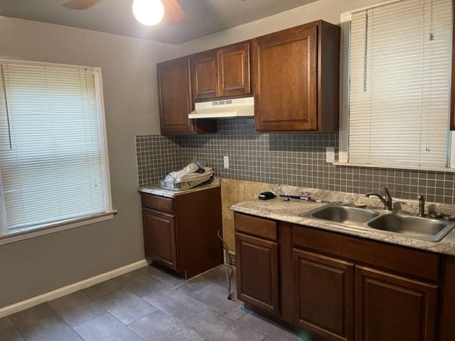 kitchen featuring decorative backsplash, ceiling fan, and sink