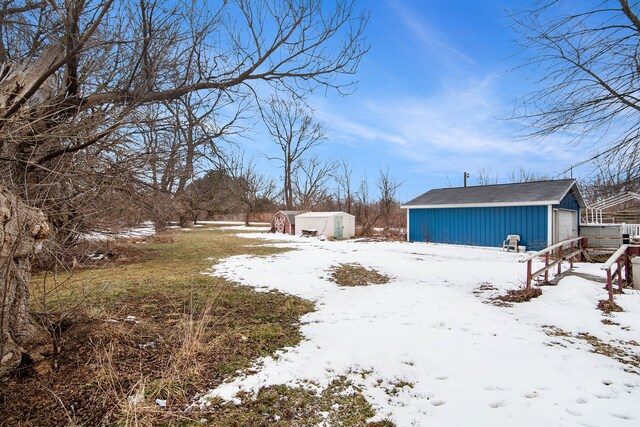 6000 N Dort Hwy, Flint, MI 48505 - snowy yard featuring an outbuilding and a garage
