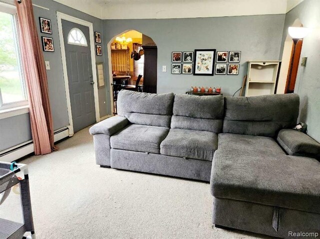 6000 N Dort Hwy, Flint, MI 48505 - carpeted living room featuring arched walkways and a baseboard heating unit