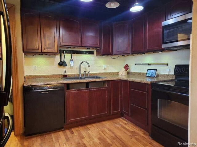 6000 N Dort Hwy, Flint, MI 48505 - kitchen featuring black appliances, a sink, reddish brown cabinets, light wood-style flooring, and backsplash