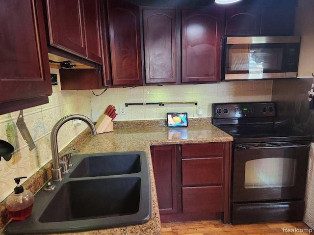 6000 N Dort Hwy, Flint, MI 48505 - kitchen with stainless steel microwave, black electric range oven, dark brown cabinets, a sink, and backsplash