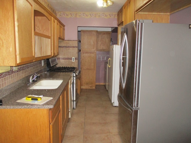 kitchen featuring light tile patterned floors, stainless steel appliances, tasteful backsplash, and sink