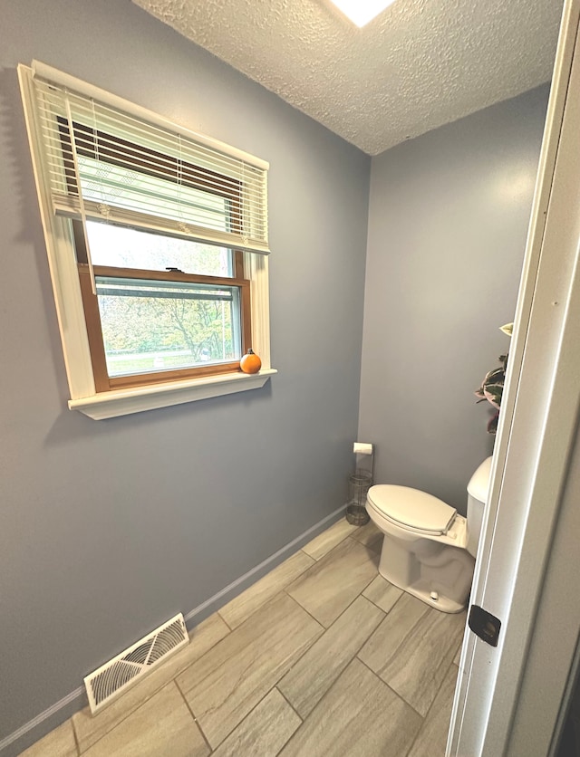 bathroom featuring a textured ceiling and toilet