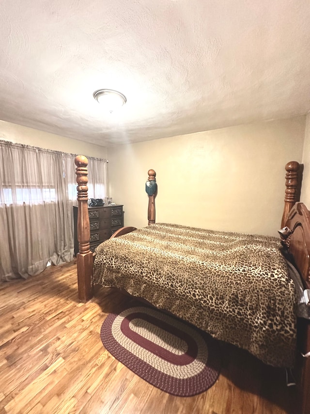 bedroom featuring a textured ceiling and light hardwood / wood-style floors