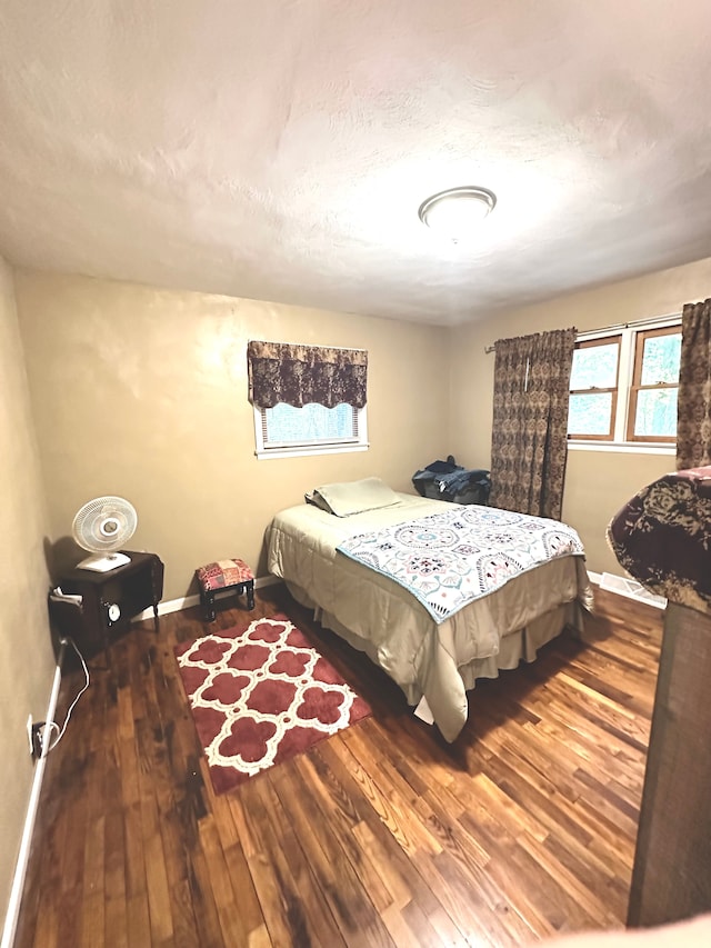 bedroom featuring wood-type flooring and a textured ceiling