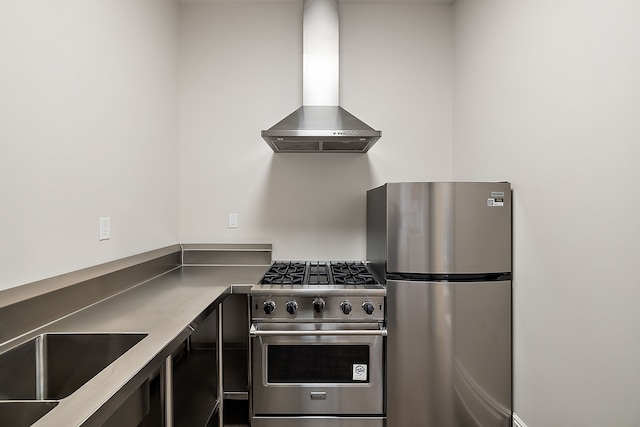 kitchen with sink, stainless steel appliances, and wall chimney range hood