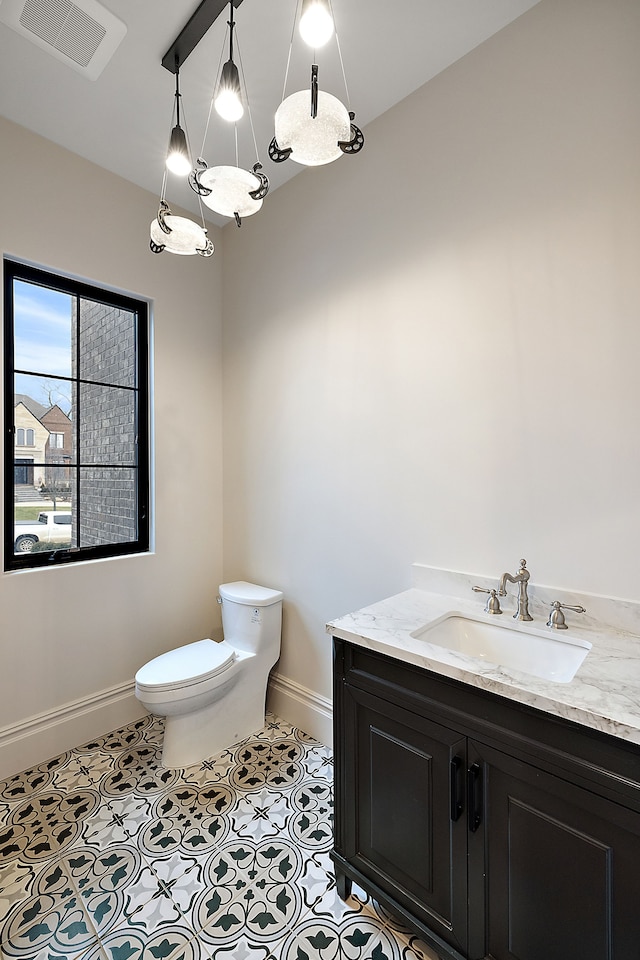 bathroom with tile patterned flooring, vanity, and toilet