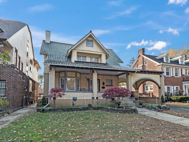 view of front facade with a front yard and covered porch