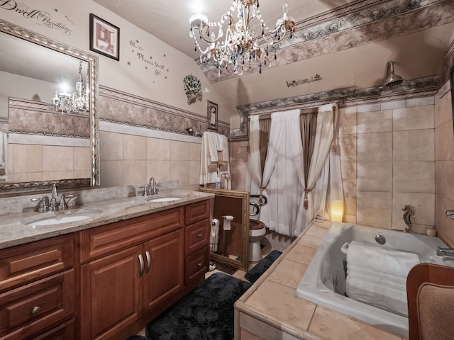 bathroom with tiled bath, vanity, tile walls, and toilet