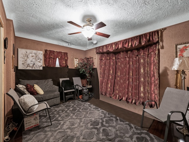 living room featuring ceiling fan, carpet, and a textured ceiling