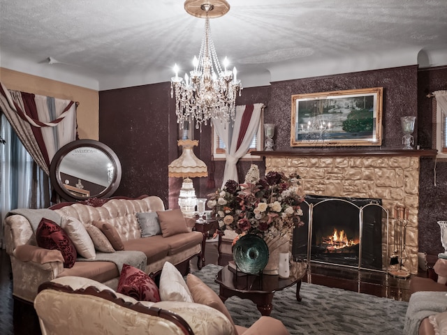 living room with a stone fireplace, a textured ceiling, and a chandelier