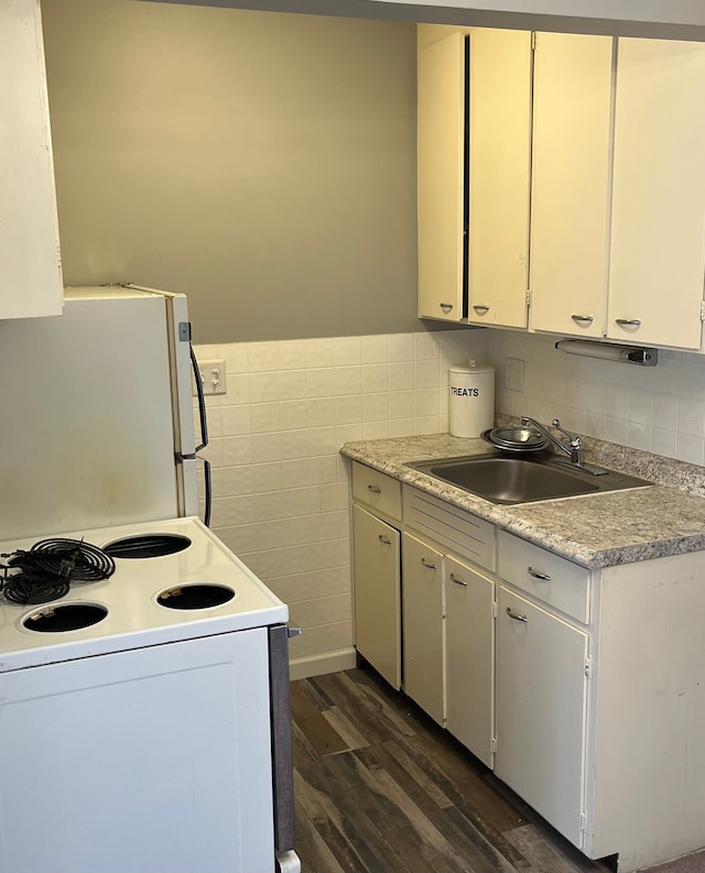 kitchen featuring white cabinetry, sink, dark hardwood / wood-style floors, white appliances, and tile walls