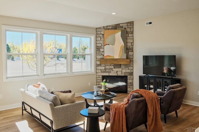 living room featuring a fireplace, wood-type flooring, and vaulted ceiling