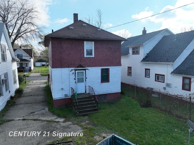 rear view of property featuring a yard