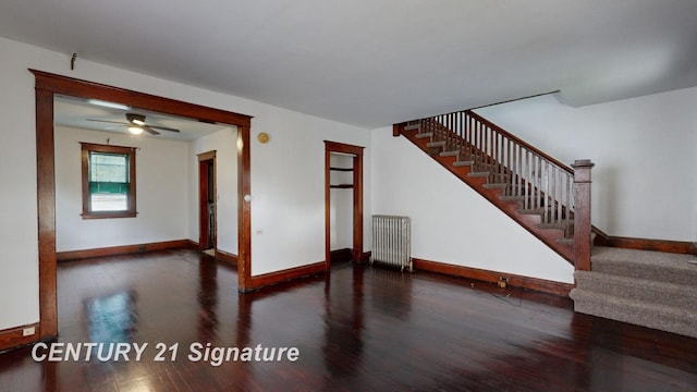 spare room with dark hardwood / wood-style flooring and radiator