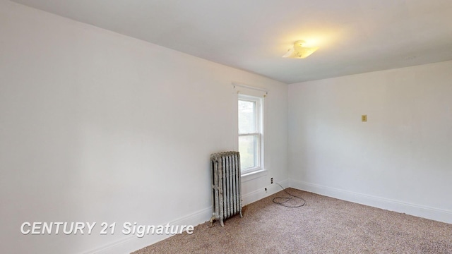 spare room featuring carpet floors and radiator heating unit