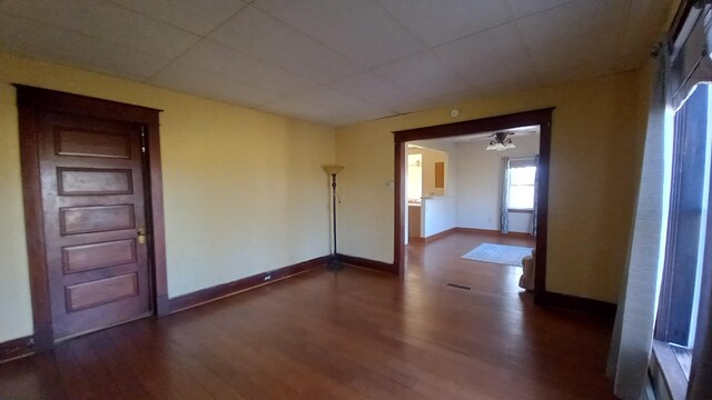2540 S Dreyer Rd, Au Gres, MI 48703 - empty room with dark wood-style flooring, baseboards, and a drop ceiling