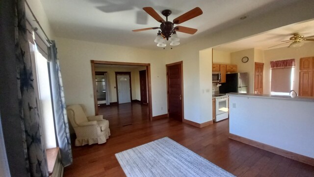 2540 S Dreyer Rd, Au Gres, MI 48703 - unfurnished living room featuring a ceiling fan, dark wood-type flooring, baseboards, and baseboard heating