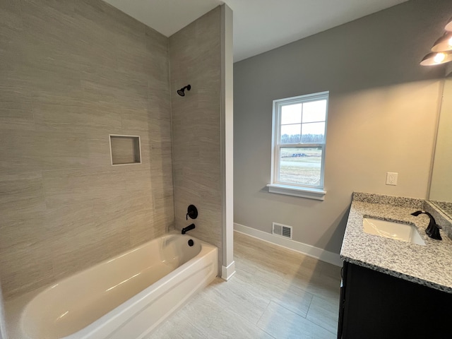 full bath with shower / bath combination, vanity, visible vents, and baseboards