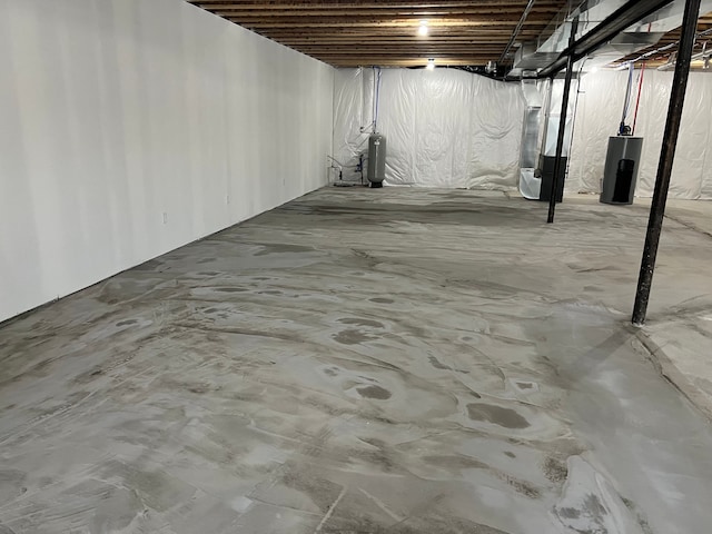 unfinished basement featuring water heater and heating unit