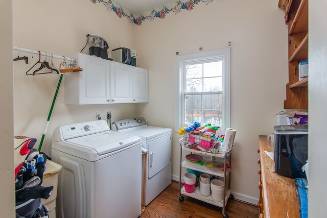 clothes washing area featuring washer and clothes dryer, dark hardwood / wood-style flooring, and cabinets