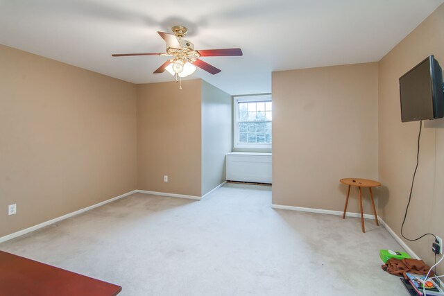 empty room featuring ceiling fan and light carpet