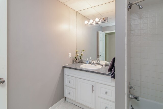 bathroom featuring tile patterned flooring, vanity, and tiled shower / bath