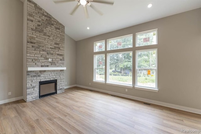 unfurnished living room with ceiling fan, light wood-type flooring, a fireplace, and high vaulted ceiling