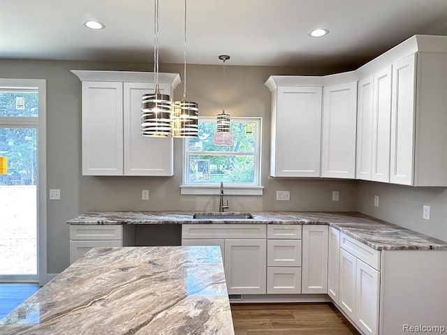 kitchen featuring pendant lighting, sink, white cabinets, and a healthy amount of sunlight