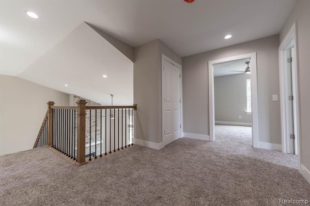 hall featuring carpet floors and vaulted ceiling