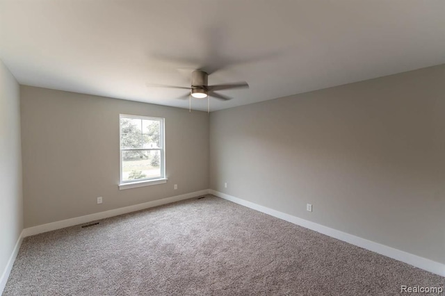 carpeted spare room with ceiling fan