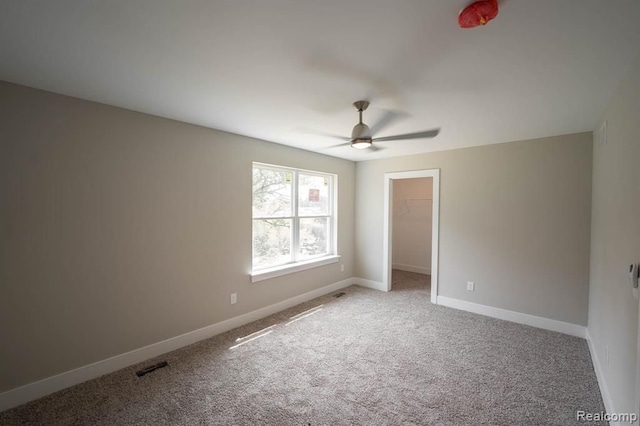 carpeted empty room featuring ceiling fan