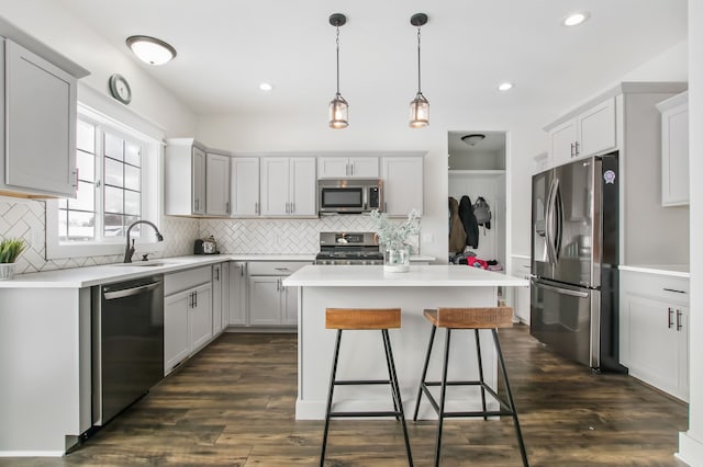 kitchen featuring gray cabinets, a center island, dark hardwood / wood-style flooring, and appliances with stainless steel finishes