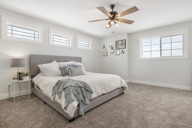 bedroom featuring multiple windows, ceiling fan, and carpet floors