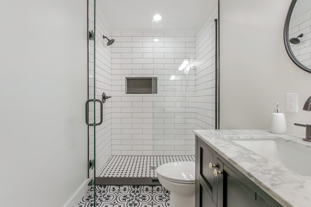 bathroom featuring tile patterned floors, vanity, an enclosed shower, and toilet