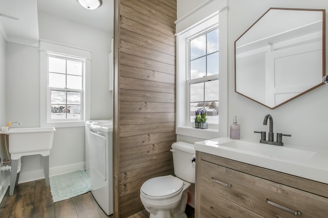 bathroom featuring washer and dryer, vanity, hardwood / wood-style flooring, and toilet