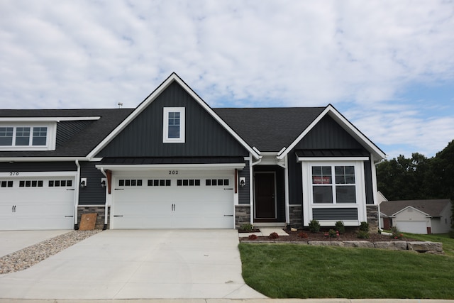 1054 Camellia Cir Unit 44, Howell, MI 48843 - craftsman-style home with stone siding, a shingled roof, concrete driveway, and a front lawn
