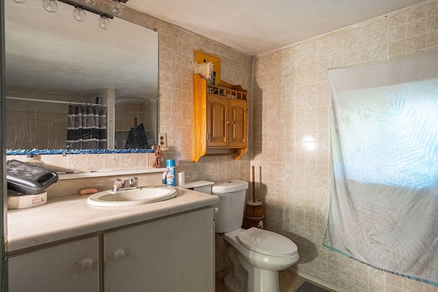 bathroom featuring a textured ceiling, vanity, tile walls, and toilet